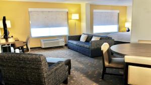 a hotel room with a couch and a bed and a table at Holiday Inn Hotel & Suites Overland Park-Convention Center, an IHG Hotel in Overland Park