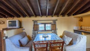 a living room with two couches and a table and a tv at Molino Los Justos - Cocineta Algarinejo by Ruralidays in Algarinejo