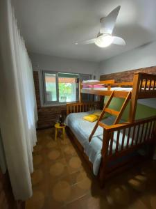 a bedroom with two bunk beds and a ceiling at Casa com os pés no mar em Iriri ES in Anchieta