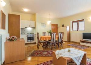 a kitchen and living room with a table and chairs at Apartments house Villa Teuta close to the sea in Umag