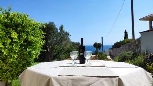 una mesa con una botella de vino y dos copas en Villa with Aegean views, en Akhladherí