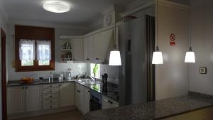 a kitchen with white cabinets and a black refrigerator at casa Costa Dorada in Les tres Cales