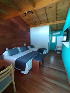 um quarto com uma cama king-size e uma televisão em El Montenegrino em Tandil