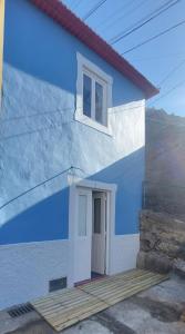 蓬塔杜索爾的住宿－Madalena Beach Tiny House，蓝色和白色的建筑,设有门和窗户