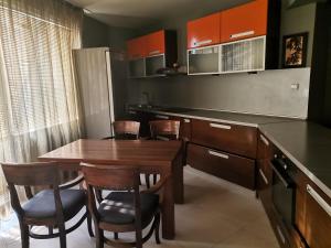 a kitchen with a wooden table and some chairs at Vival Hotel in Vidin
