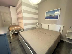 a small bedroom with a bed and a chair at Silva - Appartamento in Bibione
