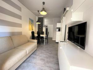 un soggiorno con divano e TV di Silva - Appartamento a Bibione