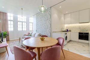 a kitchen and living room with a table and chairs at Santa Luzia Views - Modern City Centre Apartment with Iconic Views in Viana do Castelo