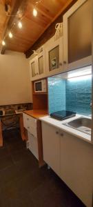 a kitchen with a sink and a counter top at Madalena Beach Tiny House in Ponta do Sol