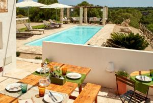 eine Terrasse mit einem Tisch und einem Pool in der Unterkunft Agroturismo Turmaden des Capita in Alaior