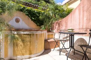 un patio con una mesa y una fuente de agua en Villa Domingues en Lisboa