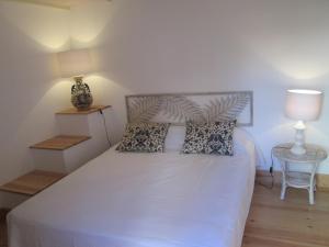 a bedroom with a white bed with a lamp and a table at Villa Domingues in Lisbon
