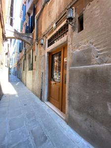 威尼斯的住宿－Alloggi Ai Tessitori，大楼内一条带木门的小巷