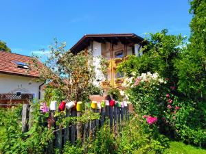 uma cerca em frente a uma casa com flores em Schlossberghof Marzoll em Bad Reichenhall