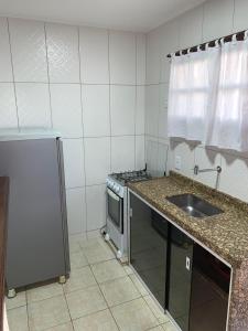 a small kitchen with a sink and a stove at Pousada Coração de Búzios in Búzios