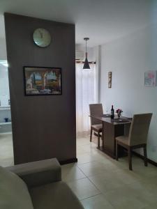 a living room with a table and a clock on the wall at APARTAMENTO ITAIGARA in Salvador