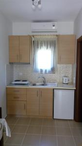 a kitchen with wooden cabinets and a sink and a window at Sivota Casa Cleopatra in Sivota