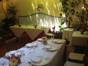 un comedor con 2 mesas con platos y copas de vino en Hotel Lancelot, en Roma