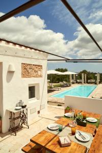 a patio with a table and a swimming pool at Agroturismo Turmaden des Capita in Alaior