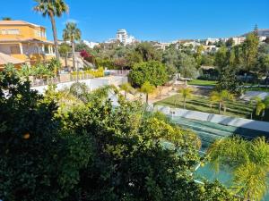 vista su un parco con palme e piscina di CASA DOCE Quinta Dos Arcos ad Alvor