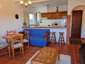 a kitchen and living room with a blue couch at CASA DOCE Quinta Dos Arcos in Alvor