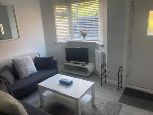 a living room with a couch and a table at Beach cottage in Gorleston-on-Sea