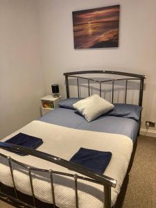 a bedroom with a bed with blue and white sheets at Beach cottage in Gorleston-on-Sea