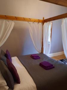 a bed with two purple towels on top of it at St Ronan's Hotel in Innerleithen
