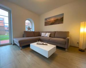ein Wohnzimmer mit einem Sofa und einem Couchtisch in der Unterkunft Lüttje Friesenhuus in Greetsiel