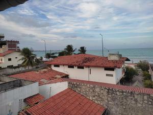 uitzicht op daken van huizen en de oceaan bij Pertinho do mar 3 in João Pessoa