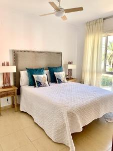 ein Schlafzimmer mit einem großen weißen Bett mit blauen Kissen in der Unterkunft Anacasa Puerta del Palmar AP2207 in Denia