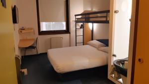 een kleine kamer met een bed en een stapelbed bij Kyriad Direct Montauban Centre in Montauban