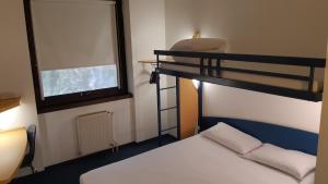 a bedroom with a bunk bed next to a window at Kyriad Direct Montauban Centre in Montauban