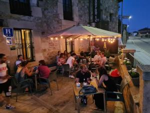 a group of people sitting at a restaurant at night at Hostal Las Nieves in Salduero