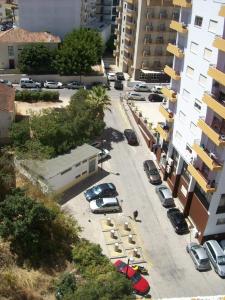 una calle de la ciudad con coches aparcados en un estacionamiento en Apartamentos Turísticos Pérola da Rocha II, en Portimão