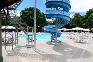 a blue water slide in a swimming pool at Hotel Sesi Aruana in Aruanã