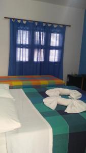EDEN Pousada في لاغوينها: غرفة نوم بسريرين عليها مناشف