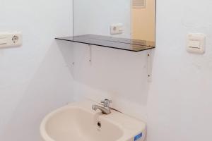 Seblat的住宿－RedDoorz Syariah @ Wisma Soponyono，浴室设有水槽和墙上的镜子
