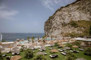a resort with a bunch of chairs and umbrellas at Maya Beach Resort in Massa Lubrense
