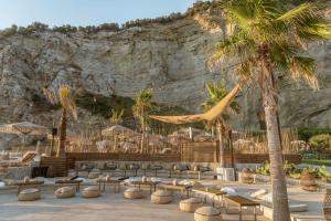 マッサ・ルブレンセにあるMaya Beach Resortの椅子とヤシの木が並ぶリゾートの様子