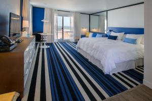 um quarto de hotel com uma cama grande e uma televisão em Montauk Blue Hotel em Montauk