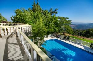 a swimming pool on a balcony with a white fence at Ha'Seuda Ha'Achrona Suites in Amirim