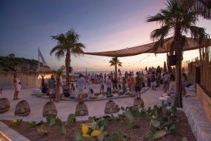 a group of people sitting in a crowd at the beach at Maya Beach Resort in Massa Lubrense