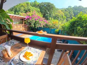a table with a plate of food and a glass of orange juice at Pousada Villa Atlântica in Camburi