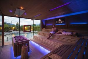 zwei Personen sitzen in einer Sauna mit Pool in der Unterkunft Majestic Hotel & Spa Resort in Bruneck