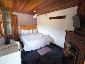 Tempat tidur dalam kamar di Pousada Da Santina