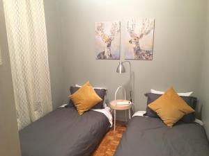 a bedroom with two beds and a table and two paintings at Le Milka II in Longueuil