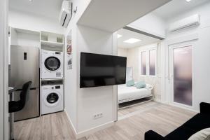 sala de estar blanca con TV de pantalla plana en Moncloa Apartment, en Madrid