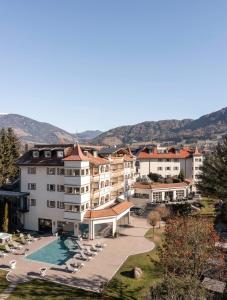 a hotel with a swimming pool and a resort at Majestic - Unique Spa Resort in Brunico