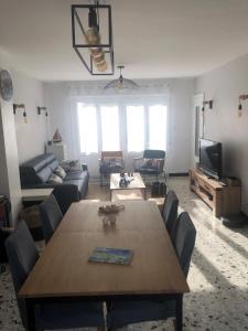 a living room with a wooden table and a couch at Du gite dans les Toiles in Wimereux